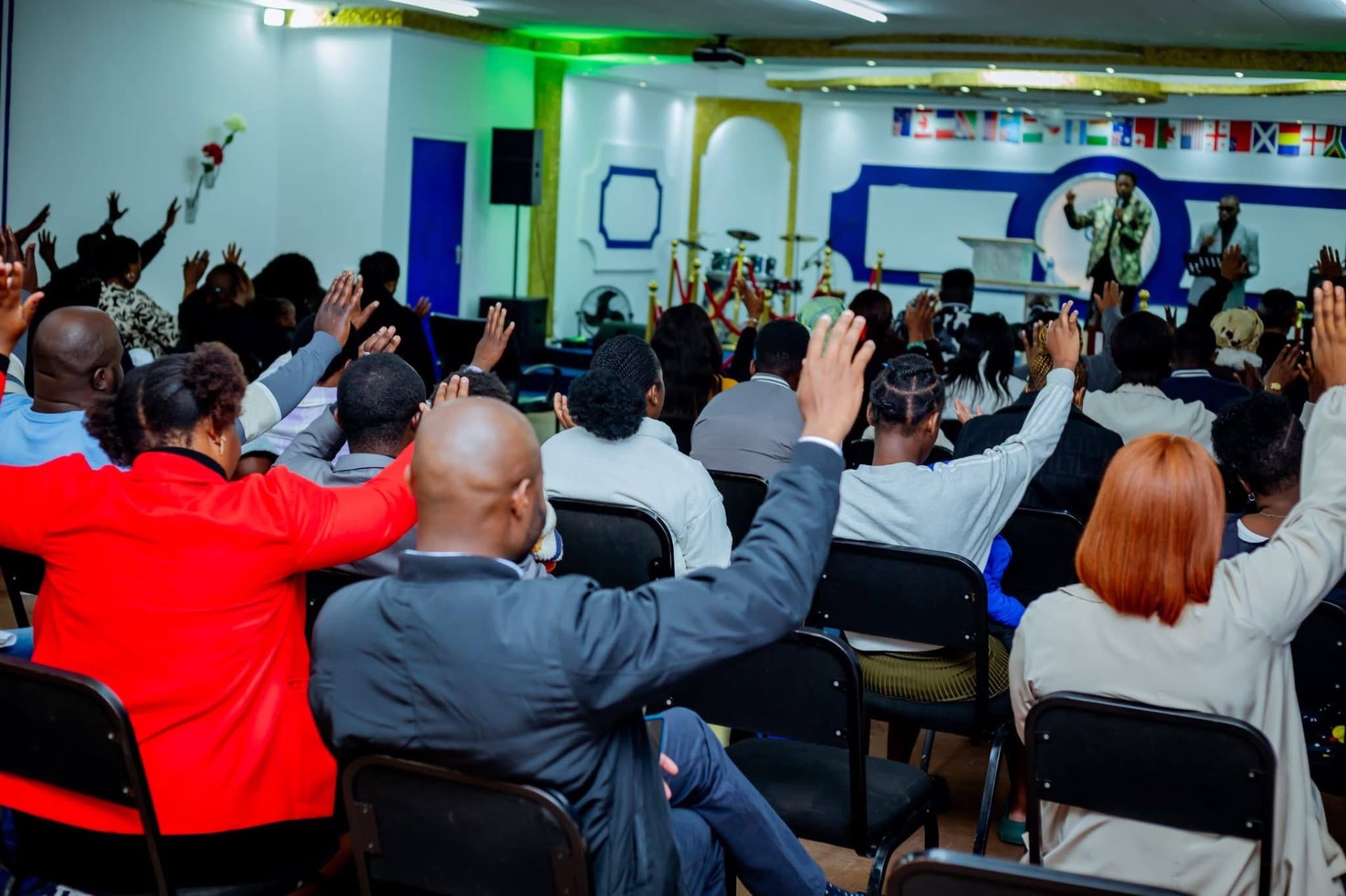 The congregation with hands raised in worship during a Sunday service
